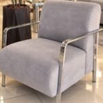 Sillon individual de pana color gris, con patas metálicas acero inoxidable